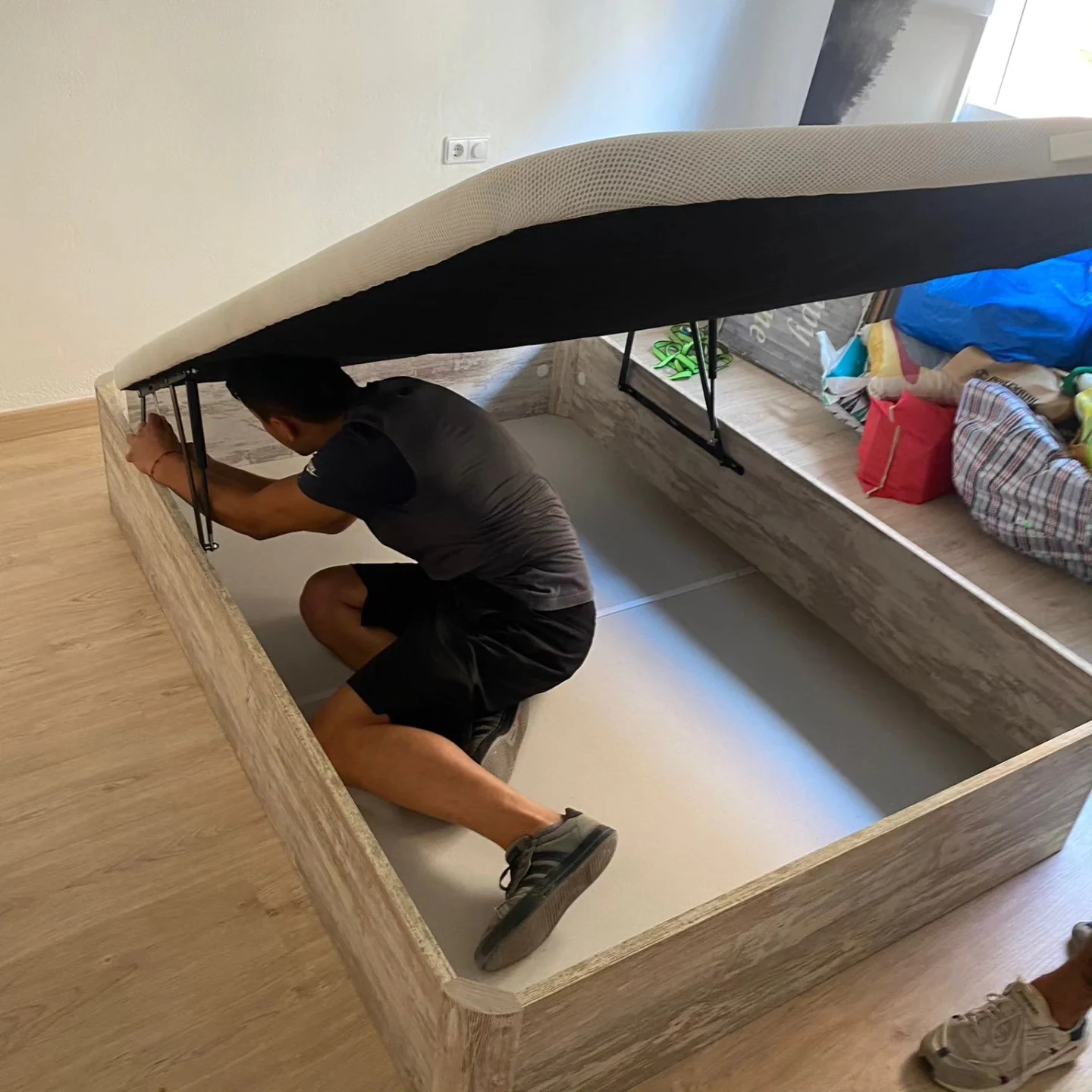 Trabajador montando una cama con almacenaje