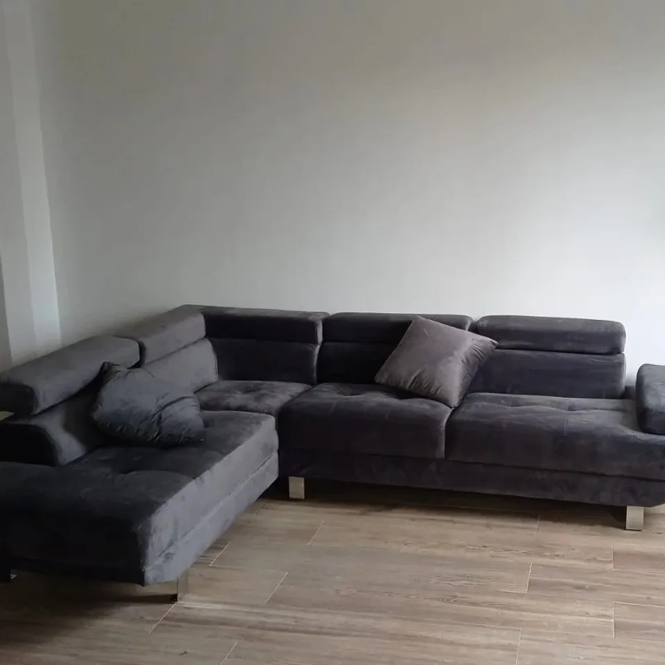 Sofá gris en forma de L instalado en un salón
