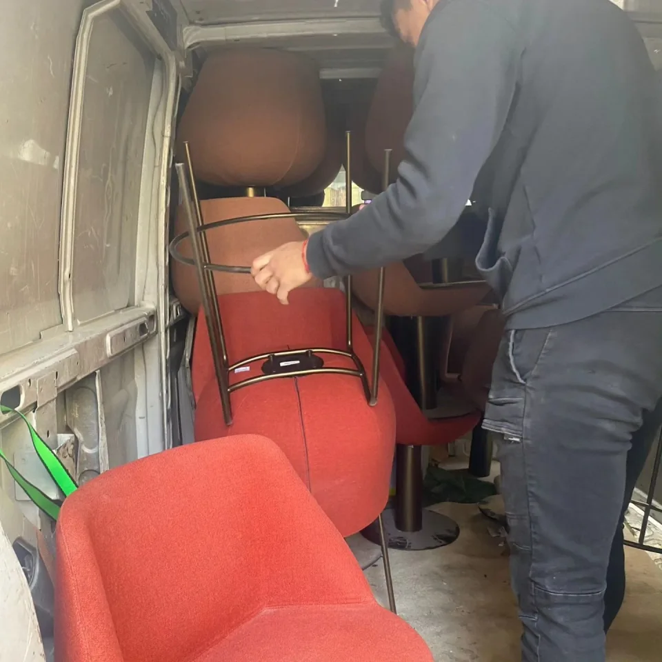 Miembro del equipo cargando sillas en una furgoneta