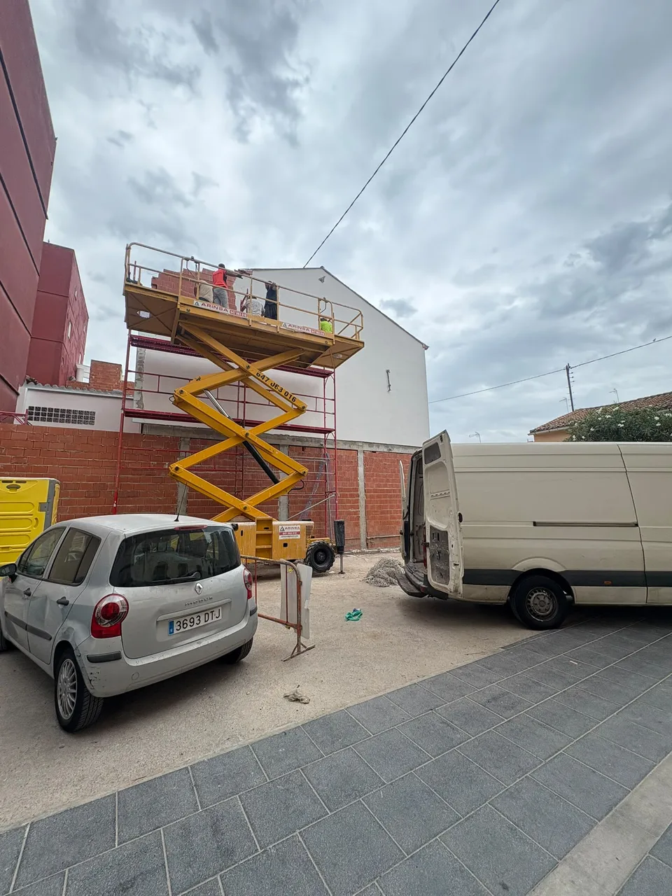 Equipo trabajando en una fachada desde una plataforma elevadora