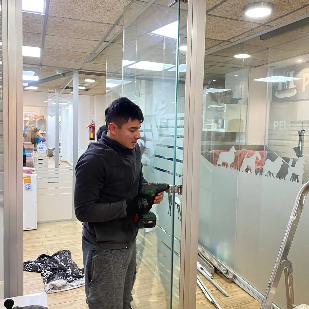 Miembro del equipo trabajando en una mampara de cristal